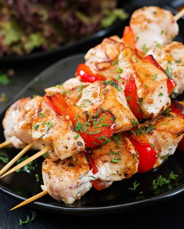 Chicken skewers with slices of sweet peppers and dill. Tasty food. Weekend meal.